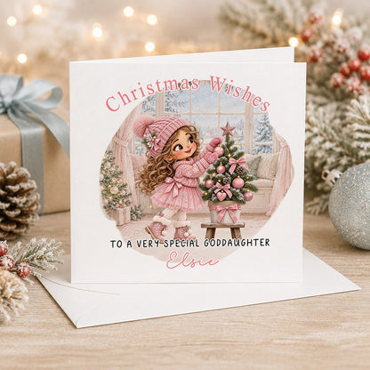 Personalised 6x6 Christmas Wishes card with a curly-haired girl decorating a small tree with pink baubles, “To a very special goddaughter Elsie”