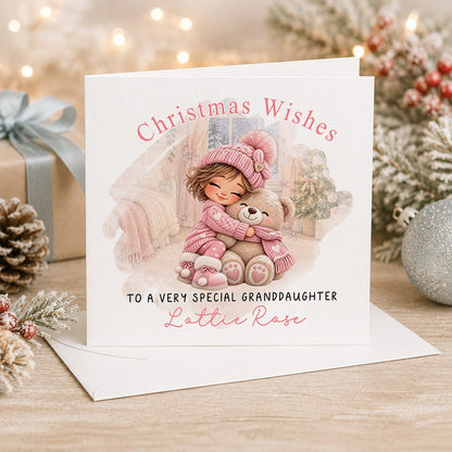Personalised 6x6 Christmas Wishes card with a little girl in a pink bobble hat hugging a teddy bear, “To a very special granddaughter Lottie Rose”