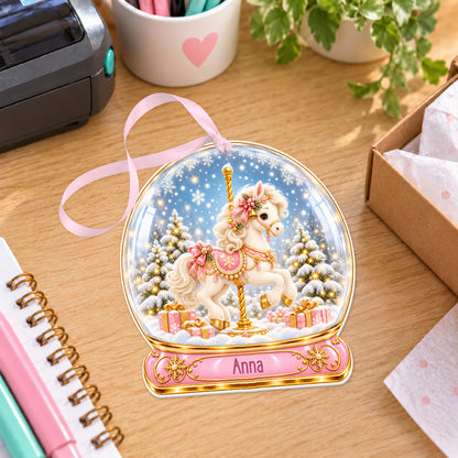 Personalised Christmas carousel snow globe bauble with name, white acrylic Christmas decoration with ribbon, shown on a desk