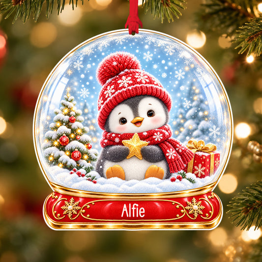 Personalised Christmas penguin acrylic snow globe Christmas bauble with custom name, hanging on a Christmas tree with red ribbon