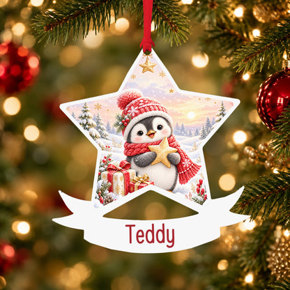 Personalised Christmas penguin acrylic star Christmas bauble with custom name, hanging on a Christmas tree with red ribbon