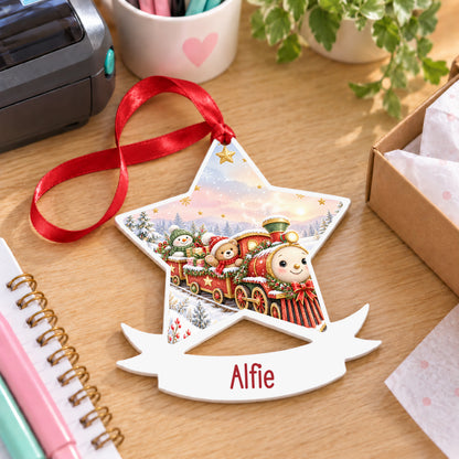 Personalised classic Christmas train white acrylic star bauble with name, 10cm Christmas decoration with ribbon, shown on a desk