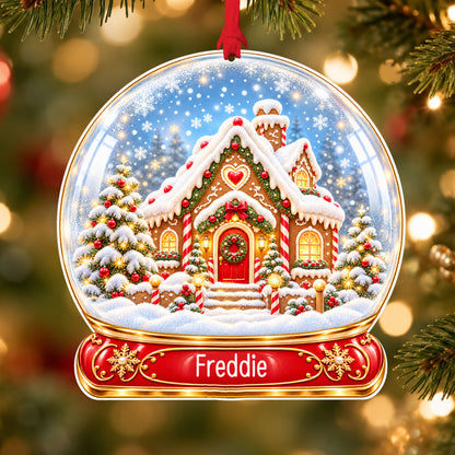 Personalised classic gingerbread house acrylic snow globe Christmas bauble with custom name, hanging on a Christmas tree with red ribbon