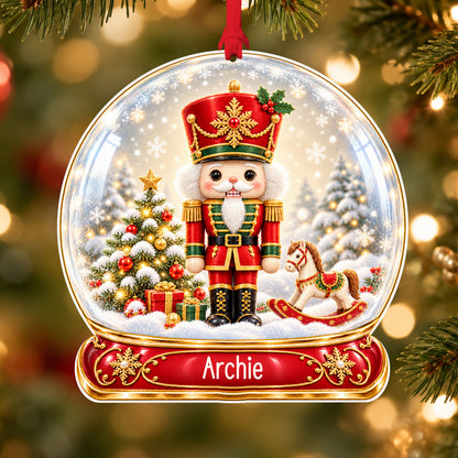 Personalised classic nutcracker acrylic snow globe Christmas bauble with custom name, hanging on a Christmas tree with red ribbon