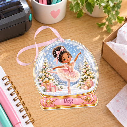 Personalised curly haired ballerina snow globe bauble with name, white acrylic Christmas decoration with ribbon, shown on a desk