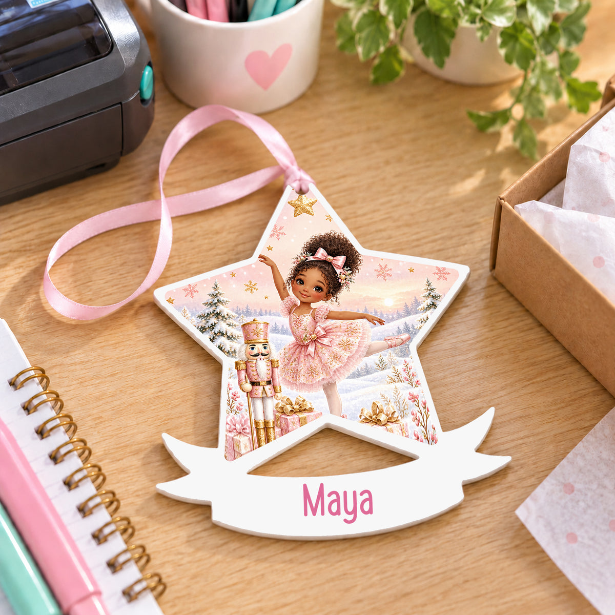 Personalised curly haired ballerina white acrylic star bauble with name, 10cm Christmas decoration with ribbon, shown on a desk