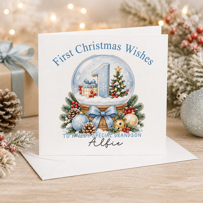 Personalised 6x6 First Christmas Wishes card with a pale blue number 1 inside a snow globe with a tiny tree and present, “To a very special grandson Alfie”