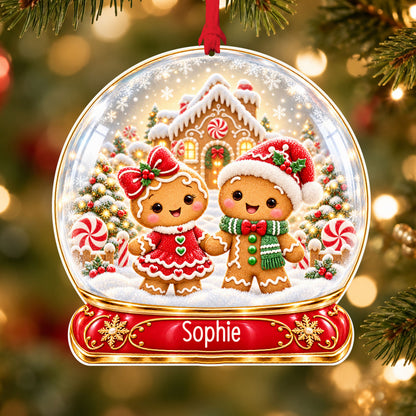 Personalised gingerbread couple acrylic snow globe Christmas bauble with custom name, hanging on a Christmas tree with red ribbon