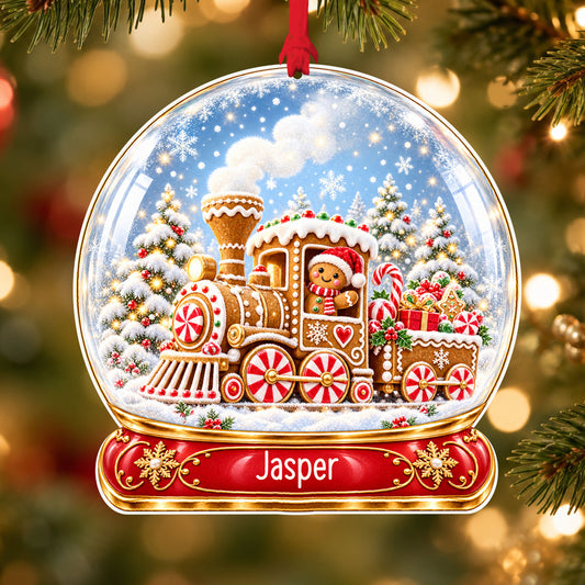 Personalised gingerbread train acrylic snow globe Christmas bauble with custom name, hanging on a Christmas tree with red ribbon