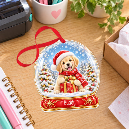 Personalised golden puppy snow globe bauble with name, white acrylic Christmas decoration with ribbon, shown on a desk
