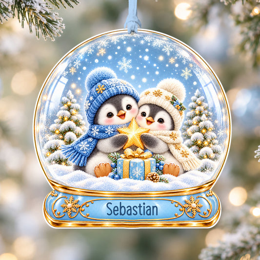 Personalised penguin buddies acrylic snow globe Christmas bauble with custom name, hanging on a Christmas tree with baby blue ribbon