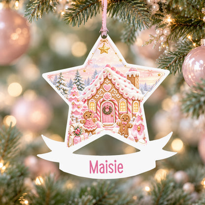 Personalised pink gingerbread cottage acrylic star Christmas bauble with custom name, hanging on a Christmas tree with baby pink ribbon