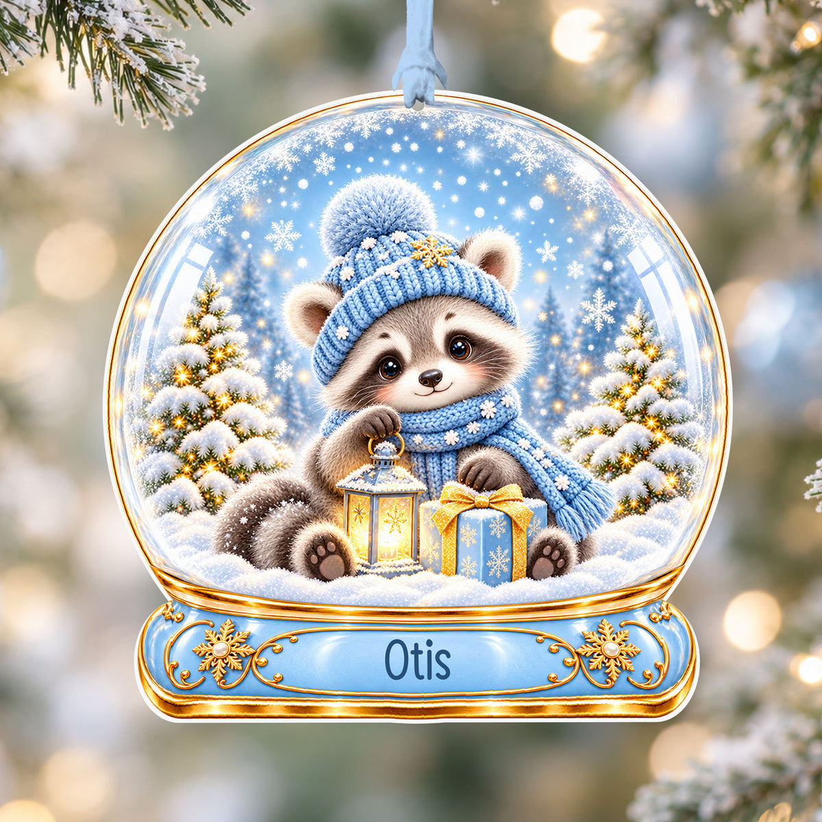 Personalised winter raccoon acrylic snow globe Christmas bauble with custom name, hanging on a Christmas tree with baby blue ribbon