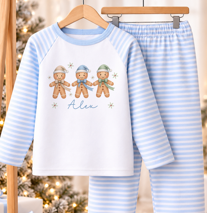 Personalised blue and white striped kids Christmas pyjamas with Gingerbread Trio design and a custom name printed on the front