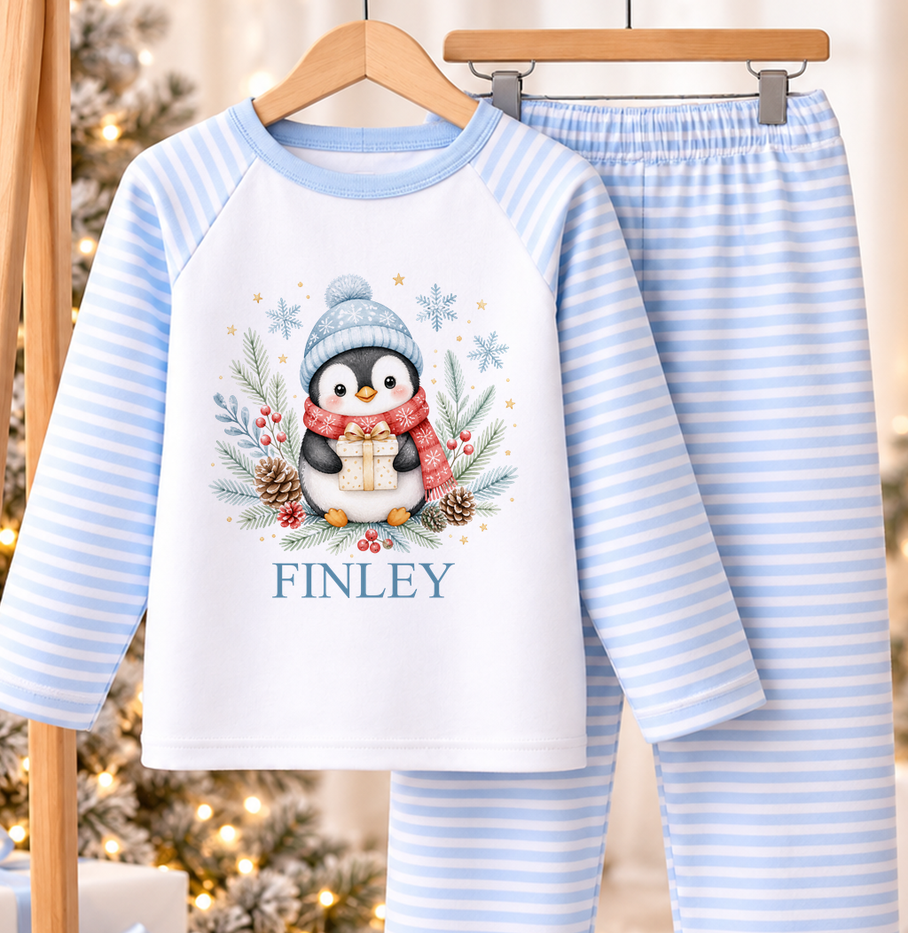 Personalised blue and white striped kids Christmas pyjamas with Penguin with Present design and a custom name printed on the front
