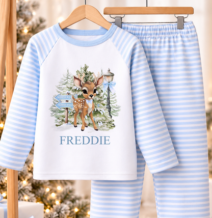 Personalised blue and white striped kids Christmas pyjamas with North Pole Fawn design and a custom name printed on the front