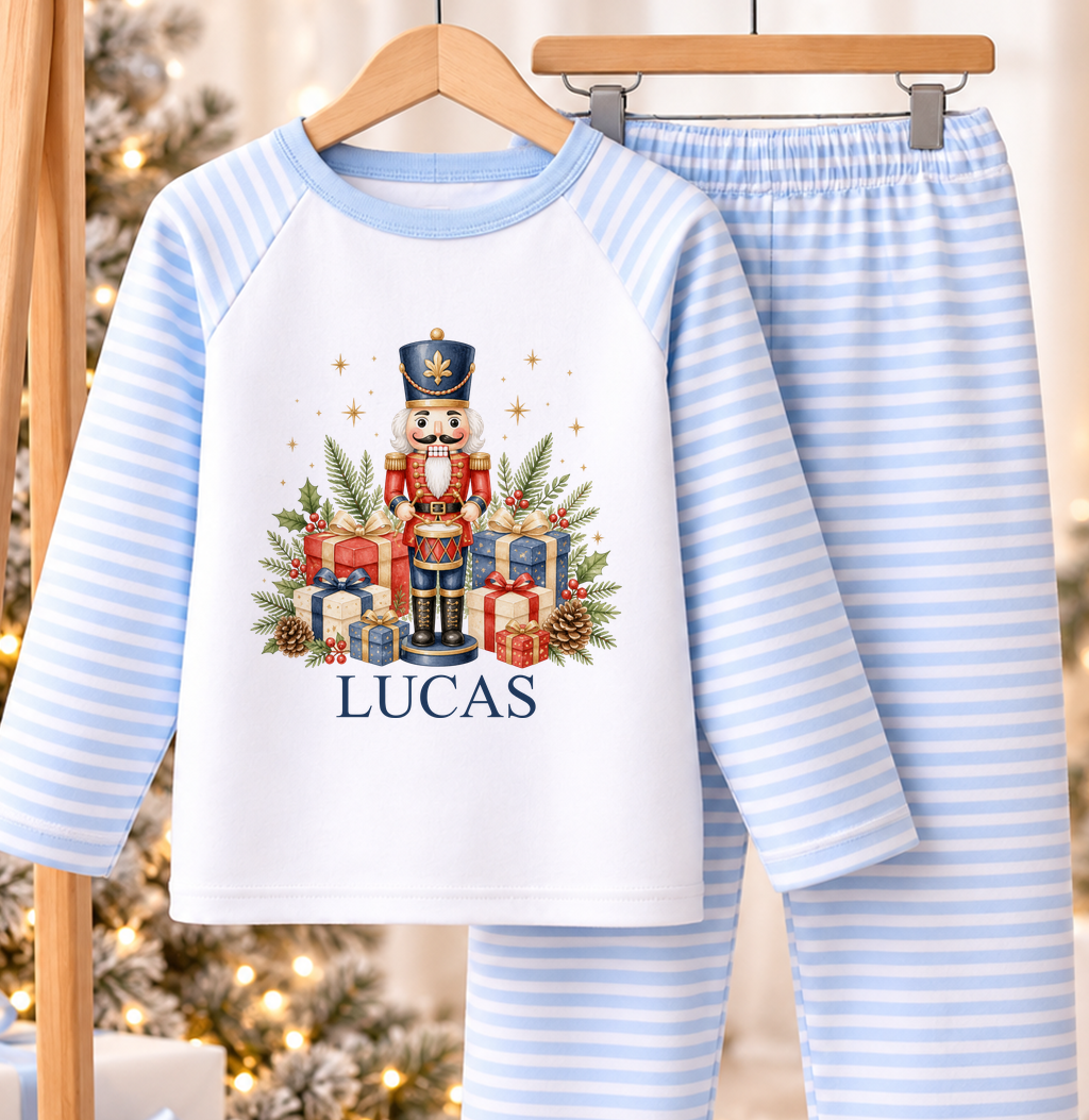 Personalised blue and white striped kids Christmas pyjamas with Nutcracker Drummer design and a custom name printed on the front