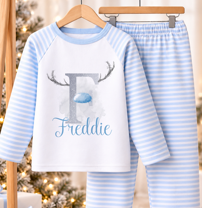 Personalised blue and white striped kids Christmas pyjamas with Reindeer Initial design and a custom name printed on the front