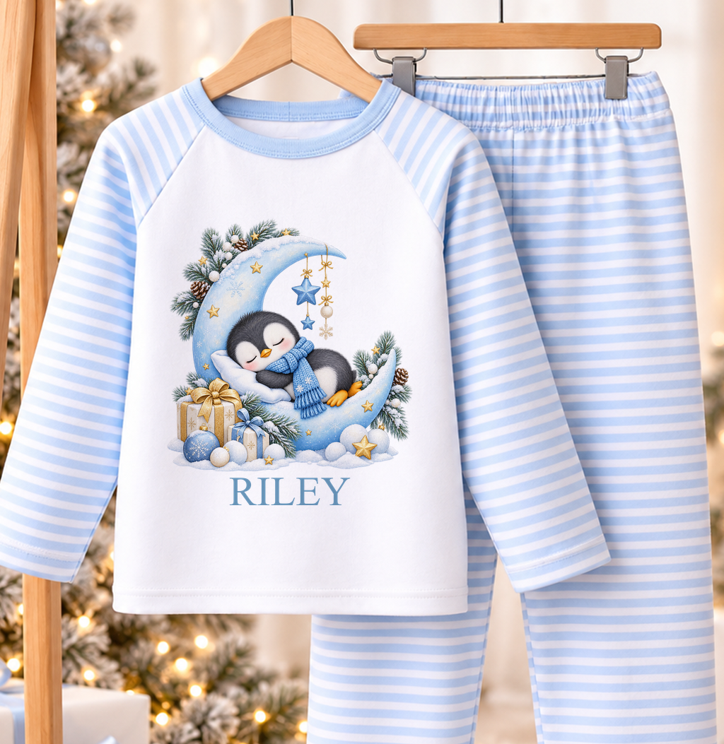 Personalised blue and white striped kids Christmas pyjamas with Sleepy Penguin Moon design and a custom name printed on the front