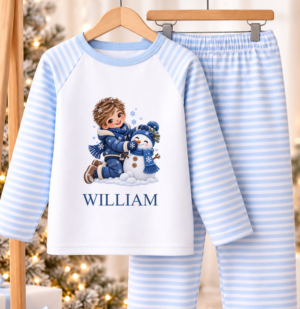 Personalised blue and white striped kids Christmas pyjamas with Boy Building Snowman design and a custom name printed on the front
