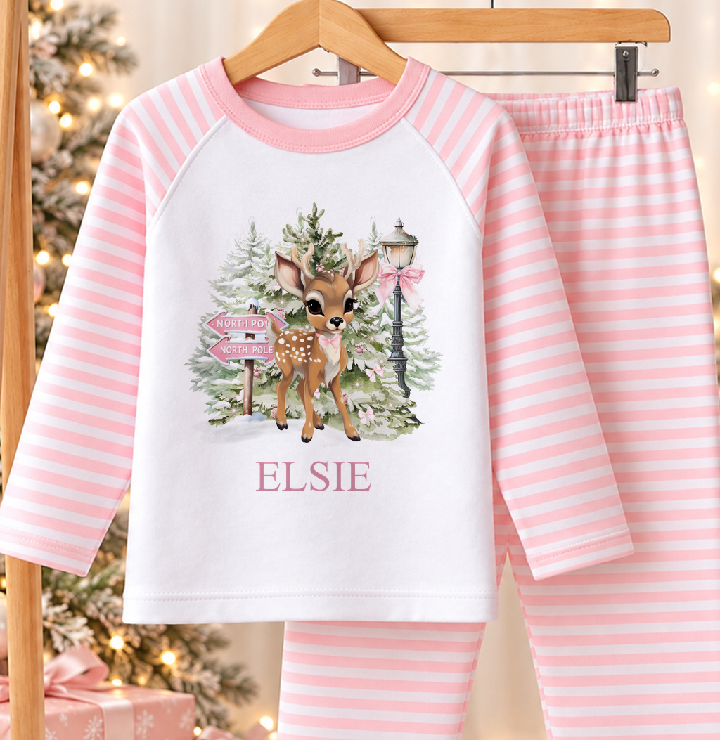 Personalised pink and white striped kids Christmas pyjamas with North Pole Fawn design and a custom name printed on the front