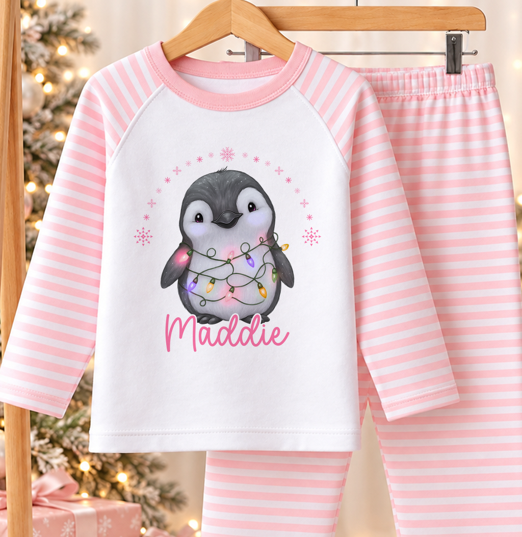Personalised pink and white striped kids Christmas pyjamas with Penguin Christmas Lights design and a custom name printed on the front