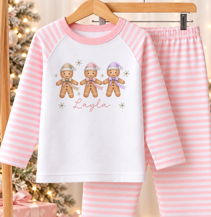 Personalised pink and white striped kids Christmas pyjamas with Gingerbread Trio design and a custom name printed on the front