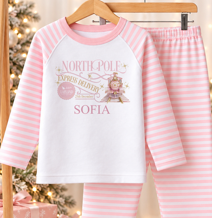 Personalised pink and white striped kids Christmas pyjamas with North Pole Express Delivery design and a custom name printed on the front