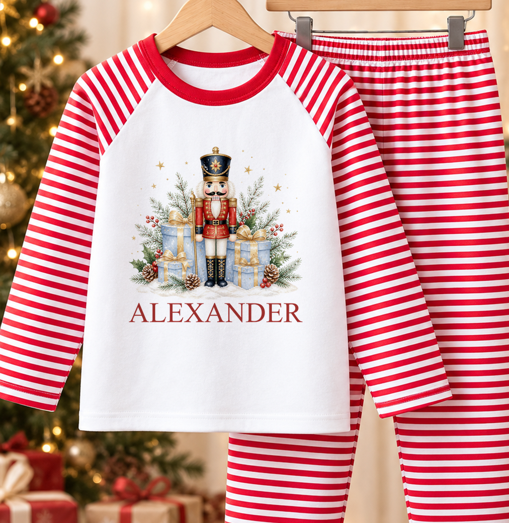 Personalised red and white striped kids Christmas pyjamas with Nutcracker Soldier and Gifts design and a custom name printed on the front