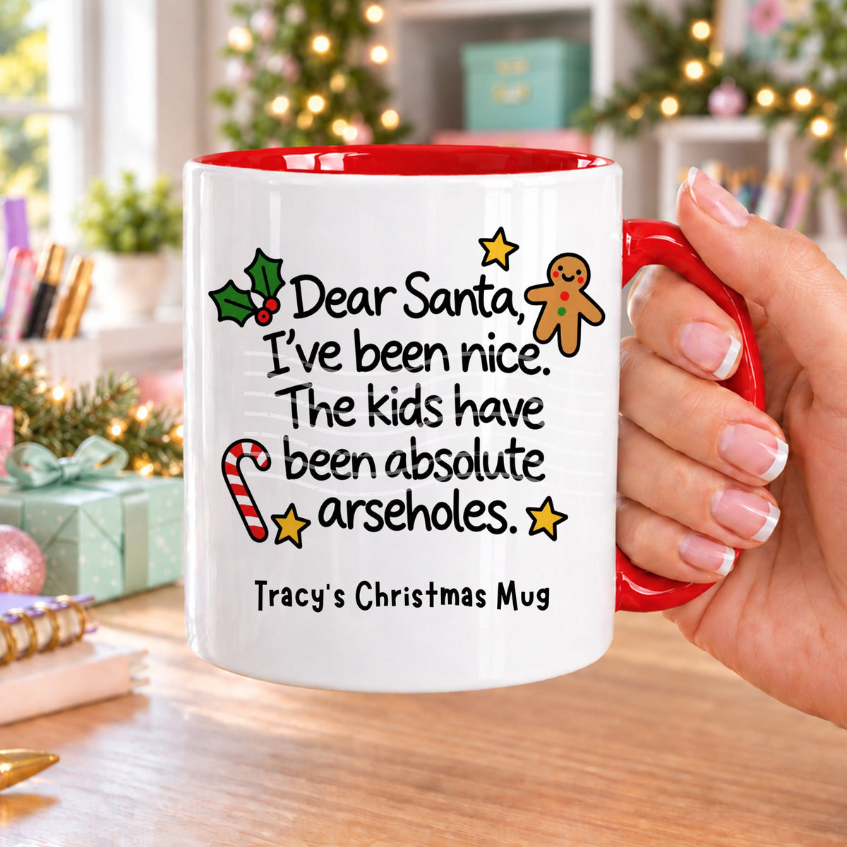 Red handled personalised funny Christmas mug printed with “Dear Santa, I’ve been nice. The kids have been absolute arseholes.” with holly, a gingerbread man, candy cane and stars, and the line “Tracy’s Christmas Mug” underneath
