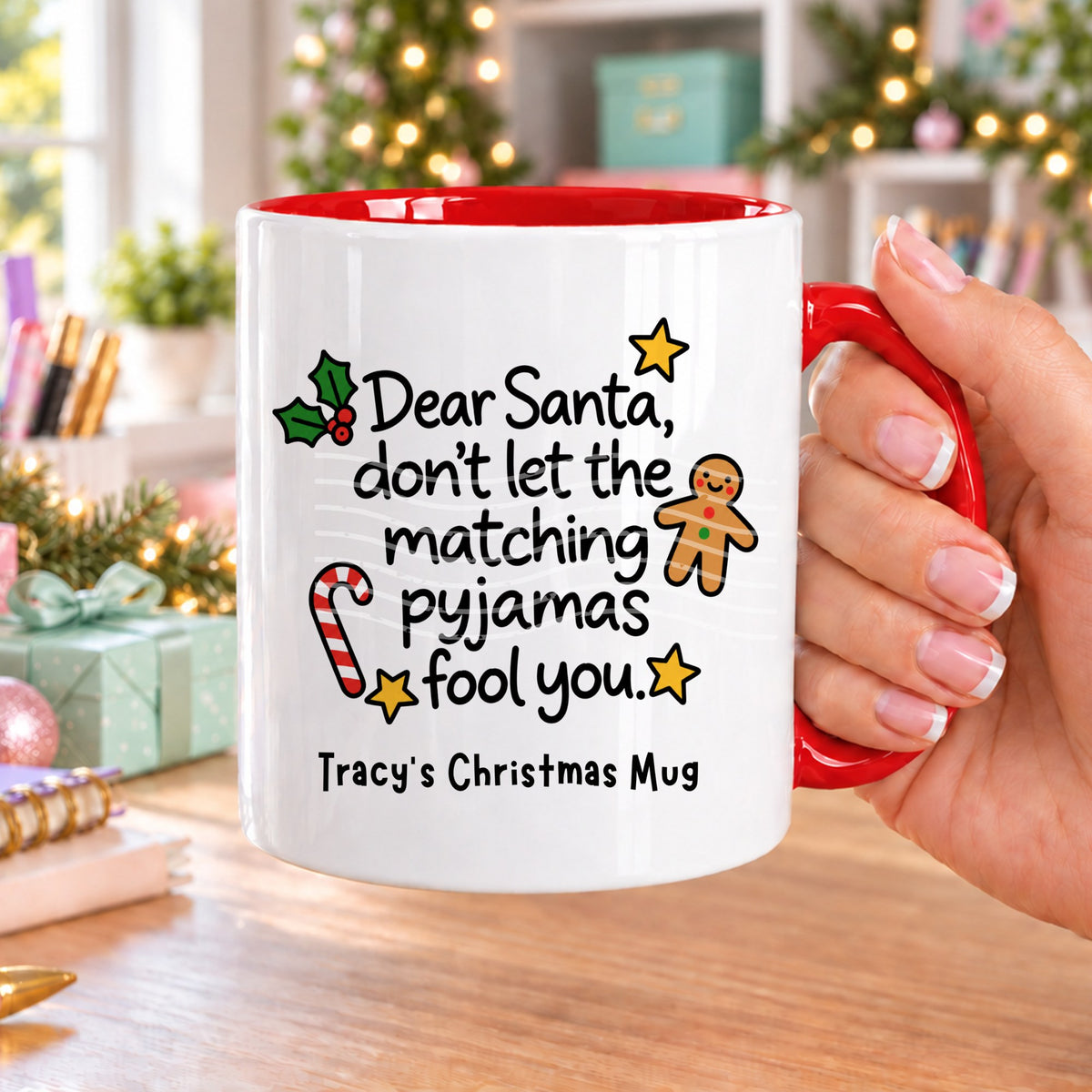 Red handled personalised funny Christmas mug printed with “Dear Santa, don’t let the matching pyjamas fool you.” with holly, a gingerbread man, candy cane and stars, and the line “Tracy’s Christmas Mug” underneath