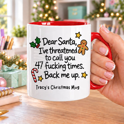 Red handled personalised funny Christmas mug printed with “Dear Santa, I’ve threatened to call you 47 f*cking times. Back me up.” with holly, a gingerbread man, candy cane and stars, and the line “Tracy’s Christmas Mug” underneath