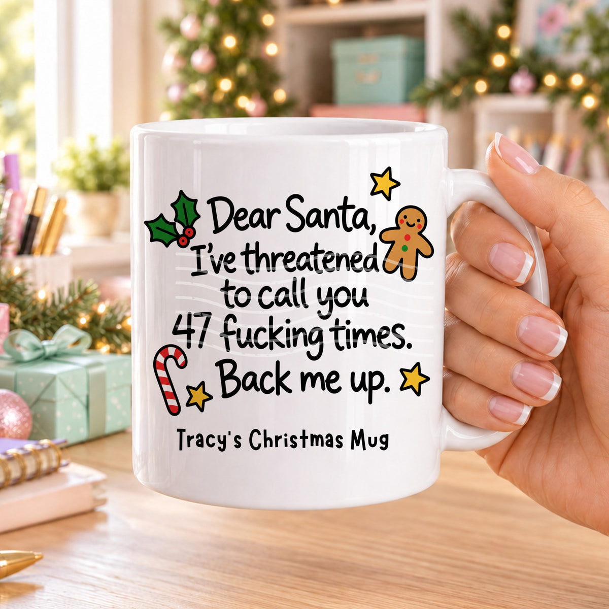 White personalised funny Christmas mug printed with “Dear Santa, I’ve threatened to call you 47 f*cking times. Back me up.” with holly, a gingerbread man, candy cane and stars, and the line “Tracy’s Christmas Mug” underneath