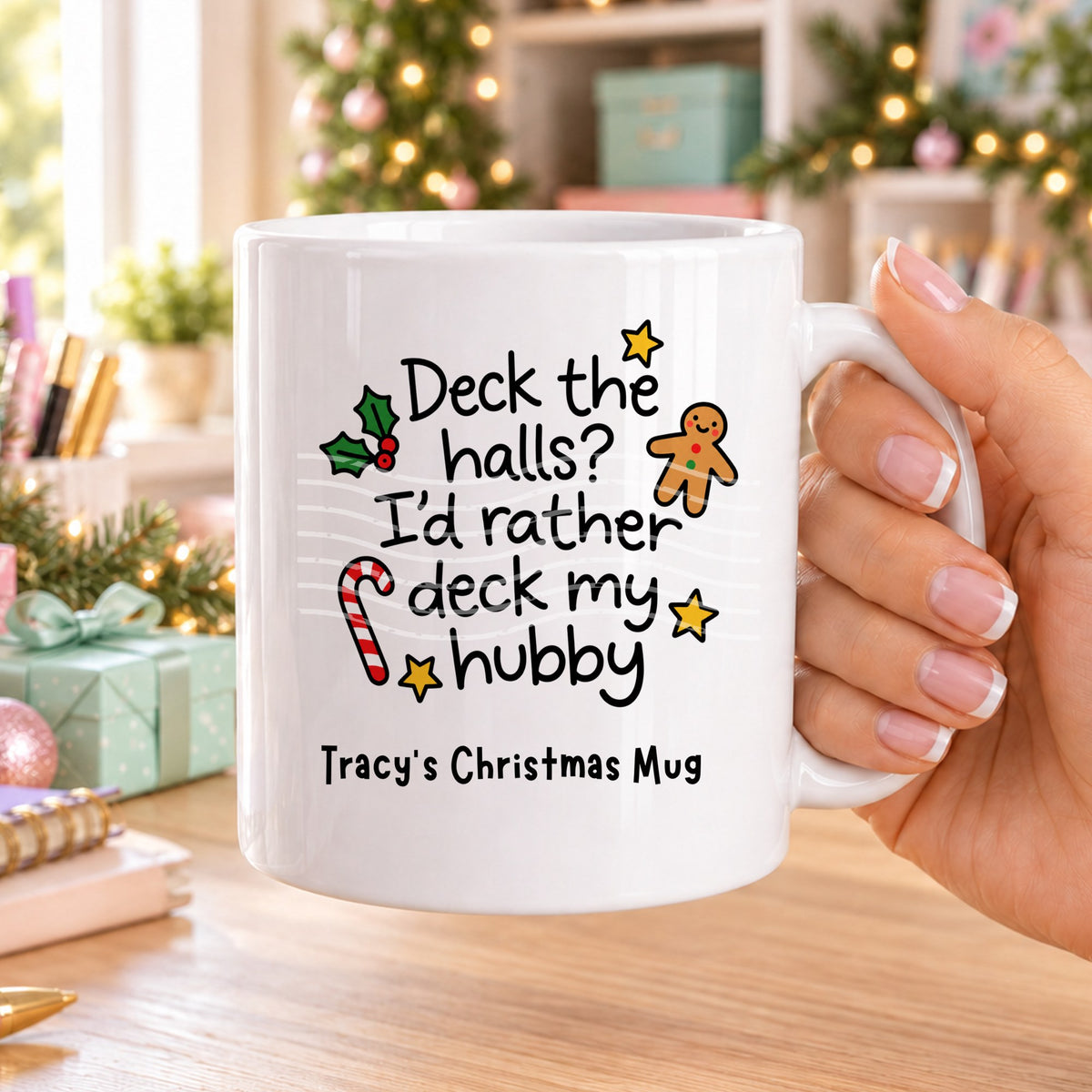 White personalised funny Christmas mug printed with “Deck the halls? I’d rather deck my hubby” with holly, a gingerbread man, candy cane and stars, and the line “Tracy’s Christmas Mug” underneath