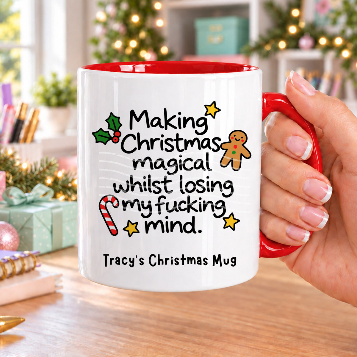 Red handled personalised funny Christmas mug printed with “Making Christmas magical whilst losing my f*cking mind.” with holly, a gingerbread man, candy cane and stars, and the line “Tracy’s Christmas Mug” underneath