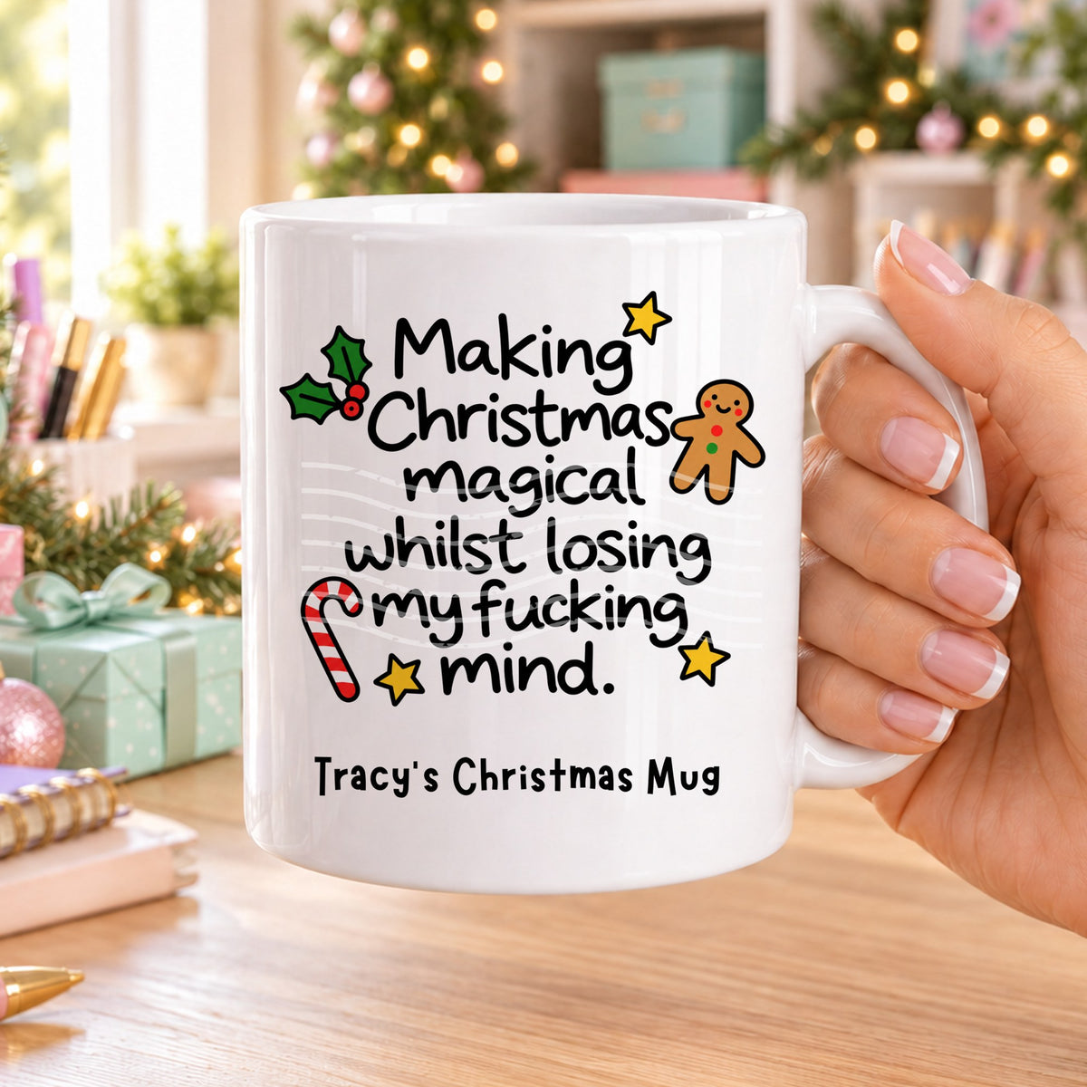 White personalised funny Christmas mug printed with “Making Christmas magical whilst losing my f*cking mind.” with holly, a gingerbread man, candy cane and stars, and the line “Tracy’s Christmas Mug” underneath