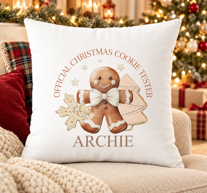 Personalised white Christmas cushion with an 'Official Christmas Cookie Tester' gingerbread design in neutral tones and a name printed underneath, on a festive sofa