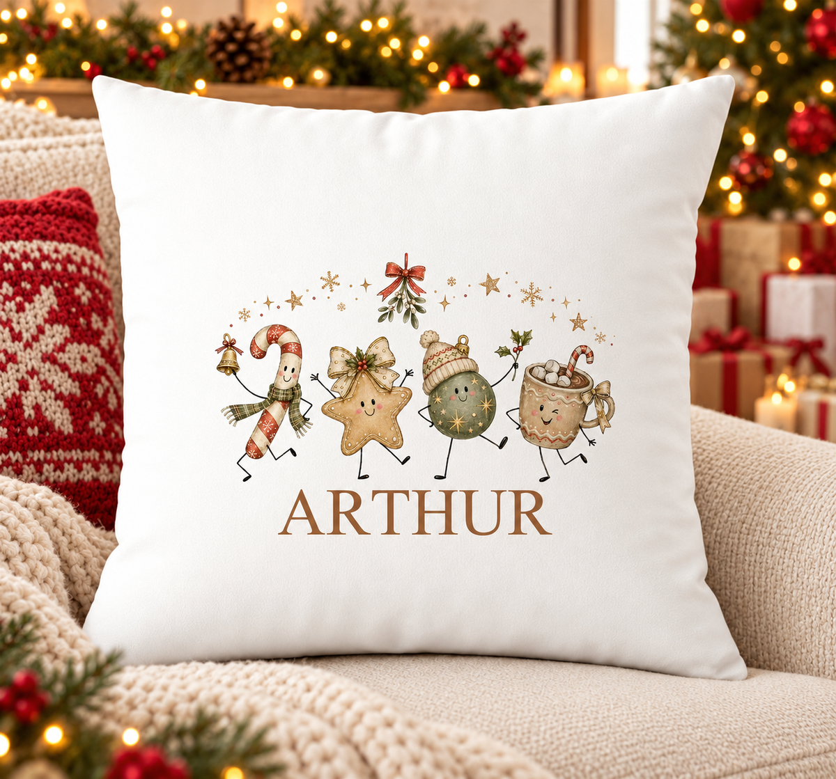 Personalised white Christmas cushion with candy cane, star, bauble and hot chocolate dancing together and a name printed underneath, on a festive sofa