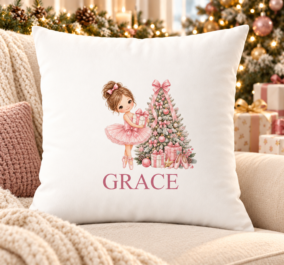 Personalised white Christmas cushion with a ballerina in a pink tutu beside a pink Christmas tree and a name printed underneath, on a festive sofa