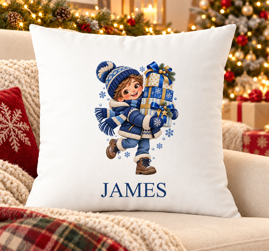 Personalised white Christmas cushion with a boy in navy knits carrying a stack of presents and a name printed underneath, on a festive sofa