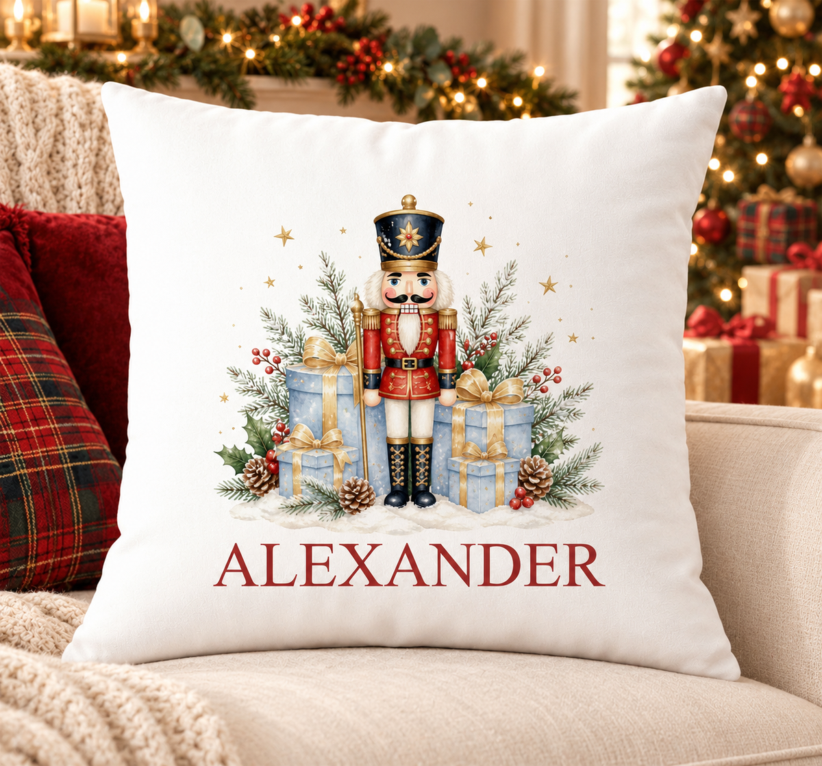 Personalised white Christmas cushion with a nutcracker soldier beside blue and gold gift boxes and a name printed underneath, on a festive sofa