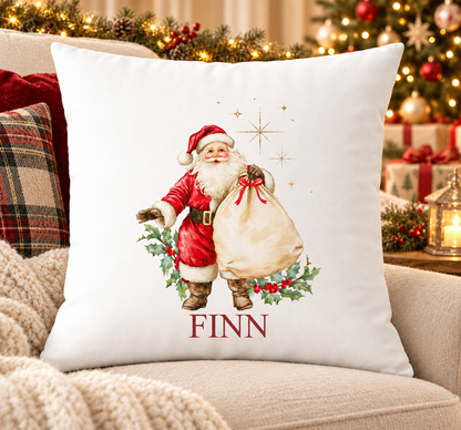Personalised white Christmas cushion with a traditional Father Christmas carrying a sack of toys and a name printed underneath, on a festive sofa