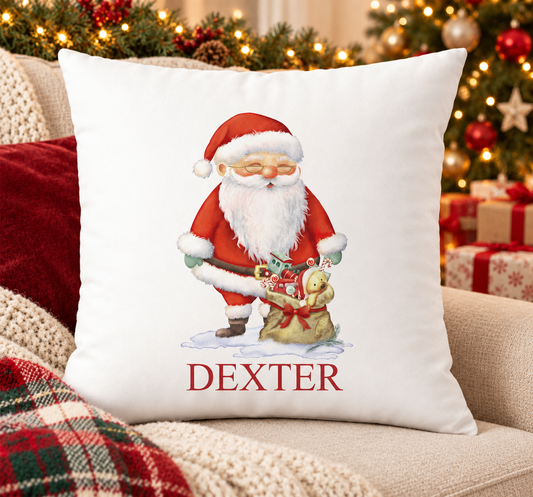Personalised white Christmas cushion with Santa with a sack full of toys and a name printed underneath, on a festive sofa