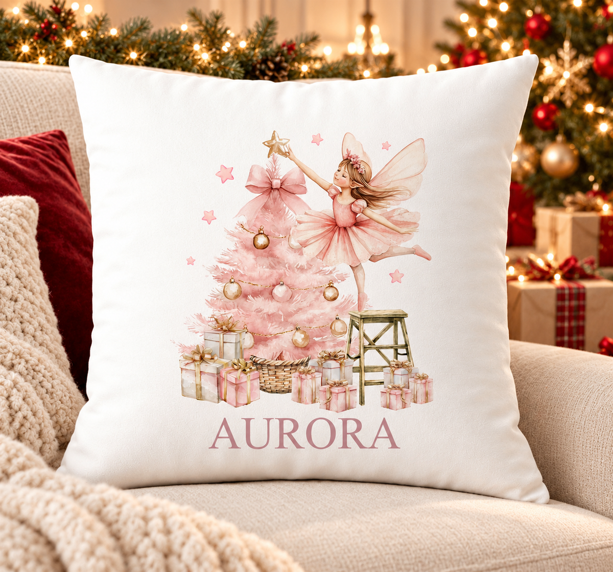 Personalised white Christmas cushion with a sugar plum fairy decorating a pink Christmas tree and a name printed underneath, on a festive sofa