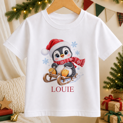 Personalised Sledging Penguin kids Christmas t-shirt in white with a custom name
