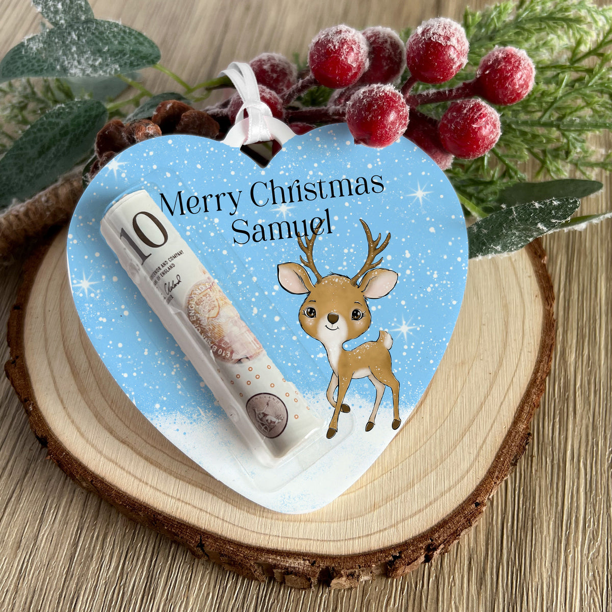 Personalised heart-shaped acrylic money pouch with a reindeer heart design, printed with a name and hung with a ribbon