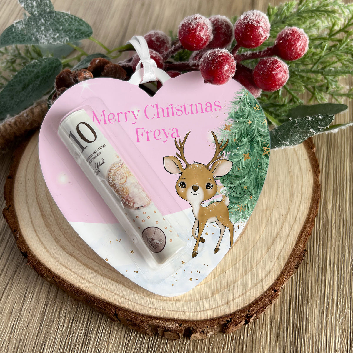 Clear acrylic heart-shaped Christmas money holder with a pink reindeer design and personalised name, ribbon attached for hanging