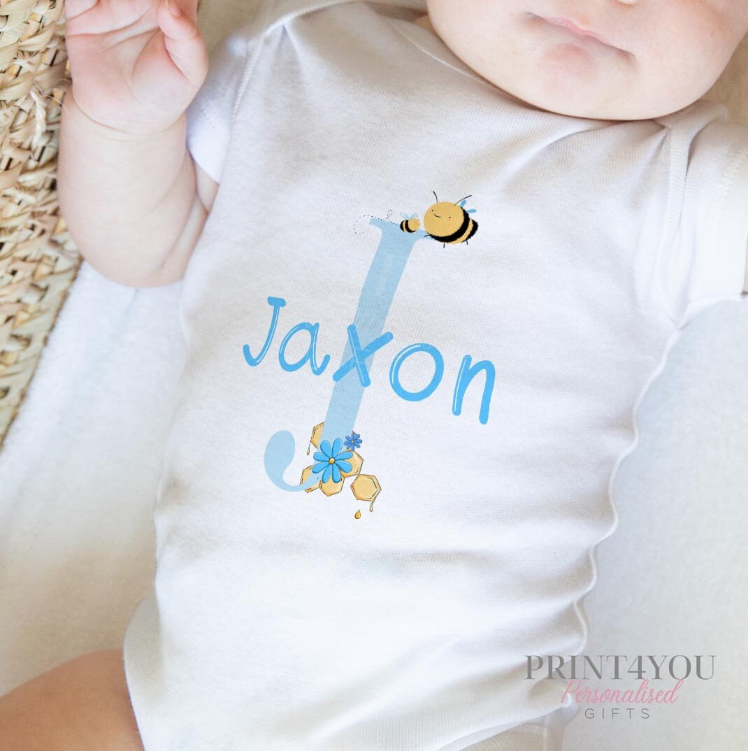 Personalised bib in soft white cotton printed with the blue alphabet and bumblebee design and baby's name.