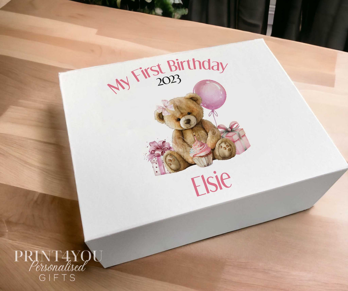 White sturdy card personalised keepsake box with magnetic closure, printed with a teddy bear, gifts and balloon design, 'My First Birthday 2023' and the name Elsie.