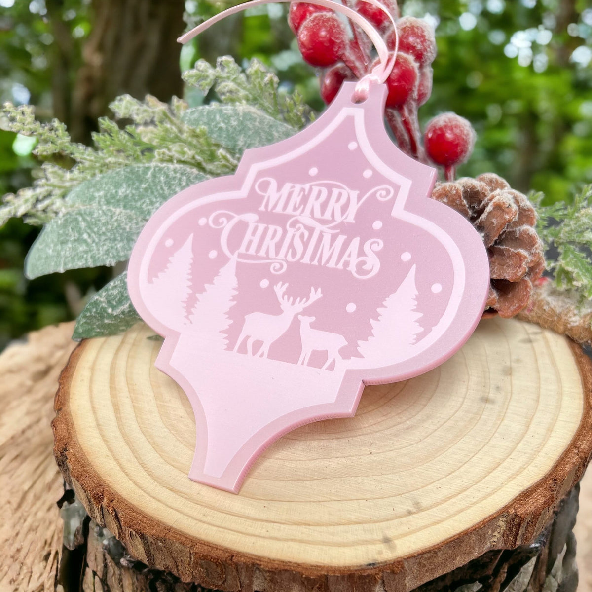 Pearlised pink arabesque acrylic Christmas bauble hanging by its ribbon